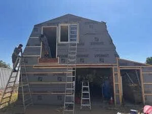 Home exterior renovation with new siding installation and professional scaffolding in progress