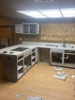 Kitchen remodel in progress with new white cabinetry, granite counters, and stainless steel appliances