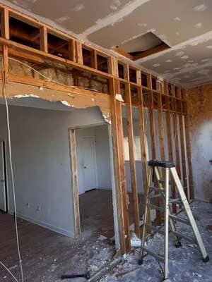 Interior framing with wooden studs and drywall installation in residential remodel project
