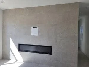 Interior drywall wall with electrical outlet box and black trim detail